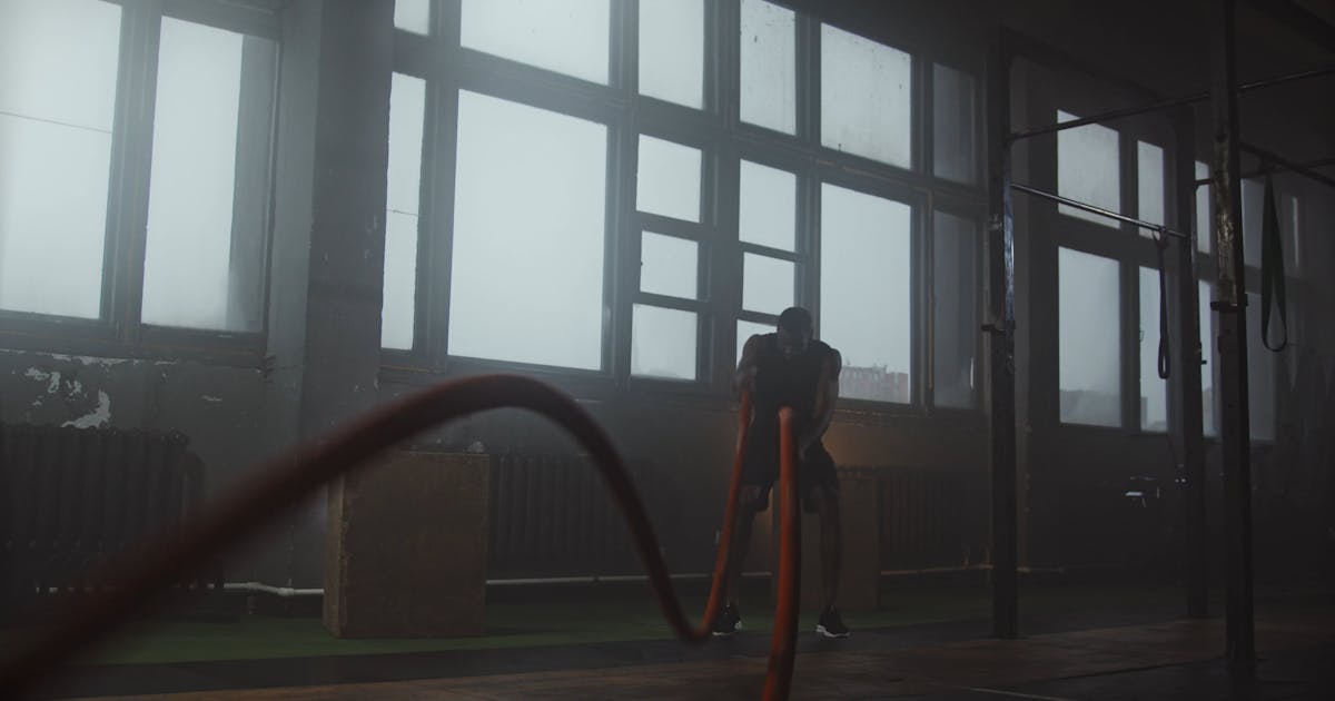 Battle ropes on the floor of an open gym with tall windows